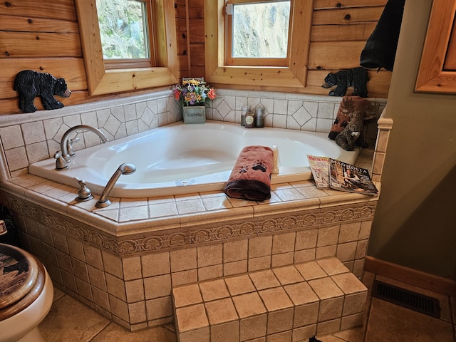 bathroom featuring tile patterned floors and tiled tub