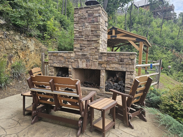 view of patio with an outdoor stone fireplace