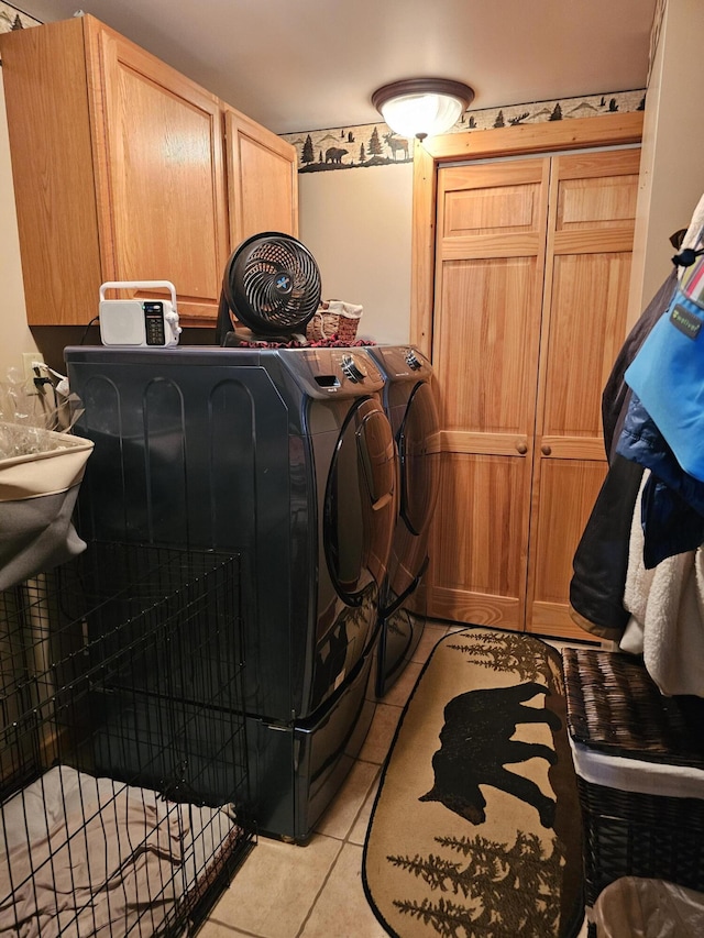 washroom featuring washer and clothes dryer, light tile patterned flooring, and cabinets