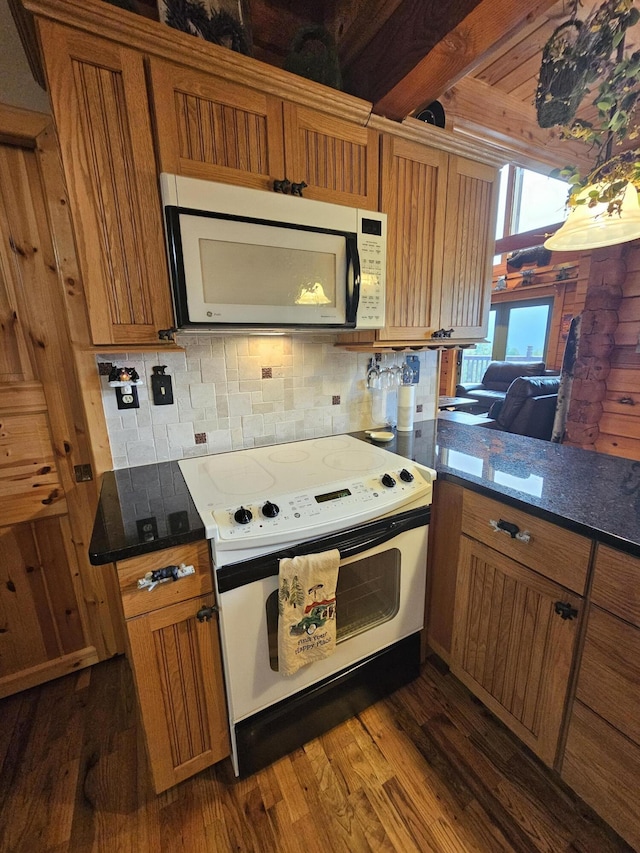 kitchen featuring beamed ceiling, white appliances, dark hardwood / wood-style floors, and kitchen peninsula