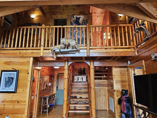 stairway featuring wood walls, hardwood / wood-style floors, and a high ceiling