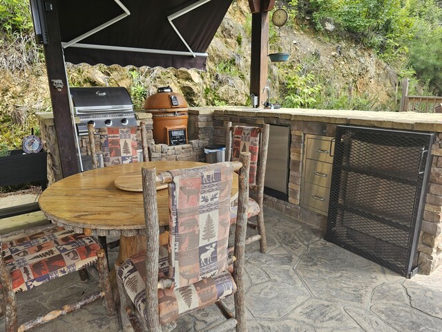 view of patio featuring an outdoor kitchen, an outdoor wet bar, and a grill