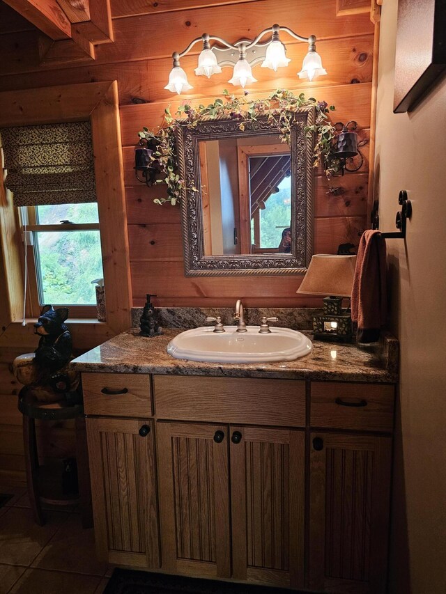 bathroom featuring tile patterned flooring, vanity, and wooden walls