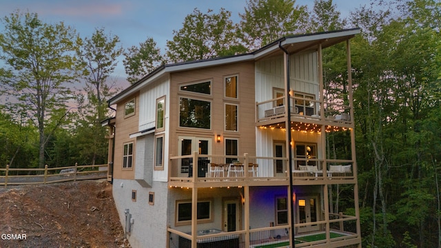 1928 Pine Ct, Sevierville, TN 37876 - back of house at dusk featuring a balcony and board and batten siding