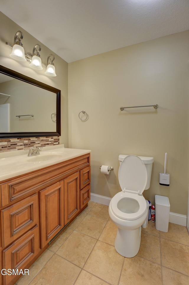 bathroom featuring toilet, tile patterned flooring, tasteful backsplash, and vanity