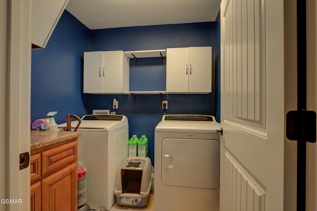 clothes washing area featuring cabinet space and washing machine and clothes dryer