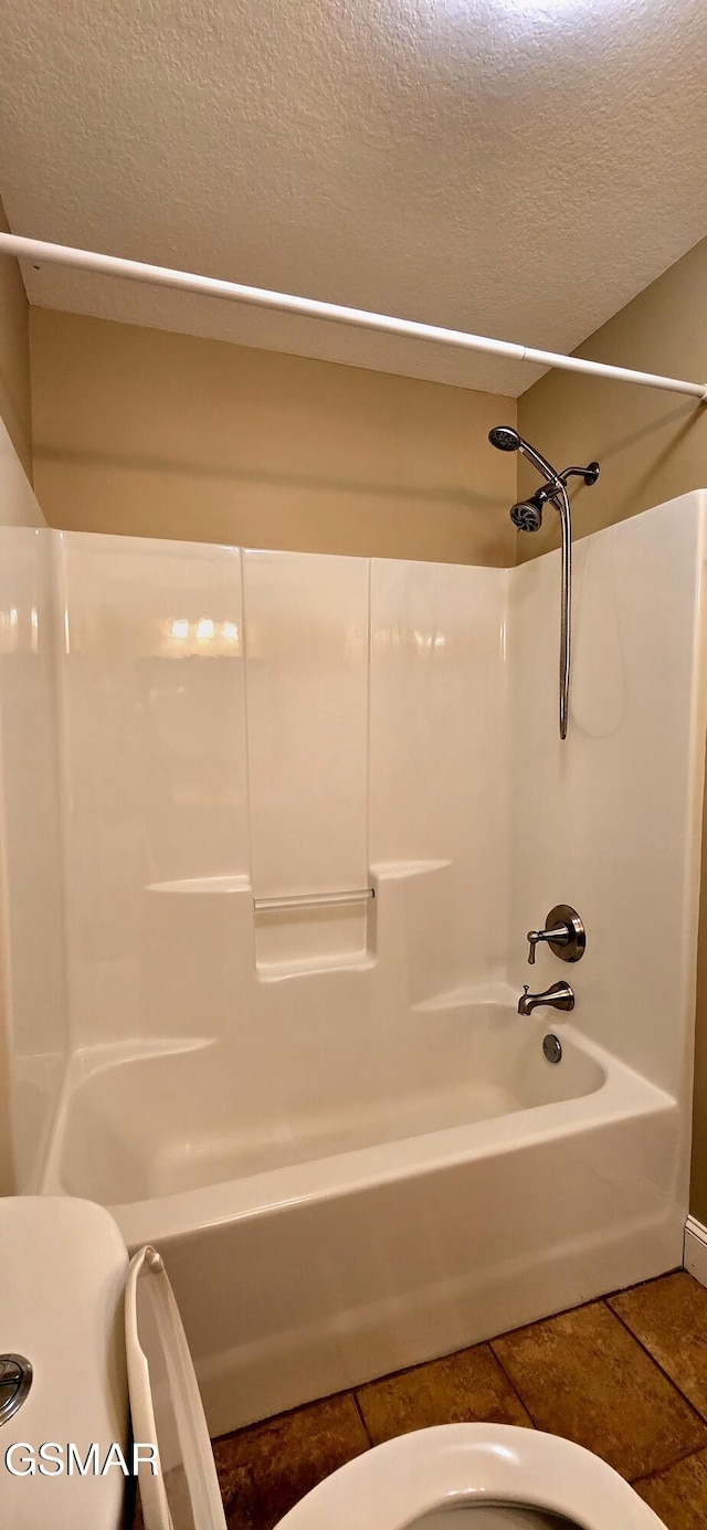 bathroom featuring a textured ceiling, shower / bathing tub combination, and tile patterned floors