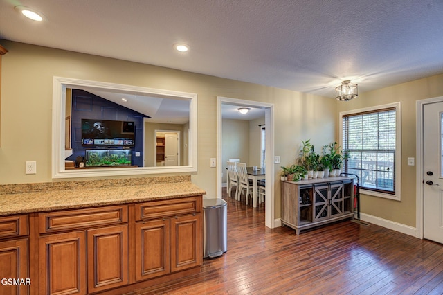 kitchen featuring light stone countertops, a textured ceiling, and dark hardwood / wood-style floors