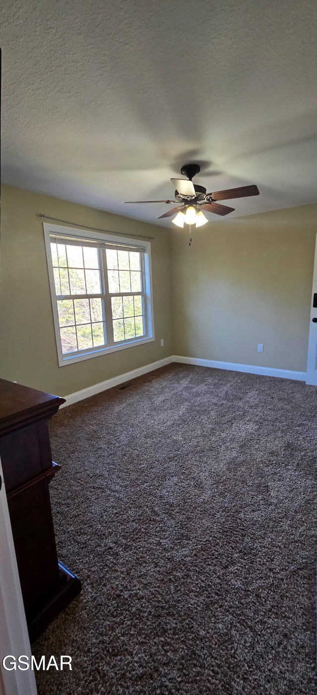 empty room featuring a textured ceiling, baseboards, and carpet flooring