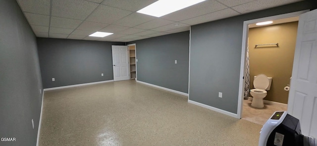 below grade area featuring a paneled ceiling and baseboards