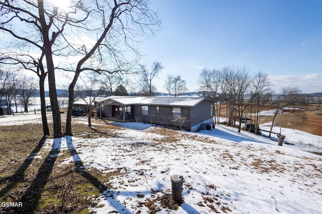 view of snow covered back of property