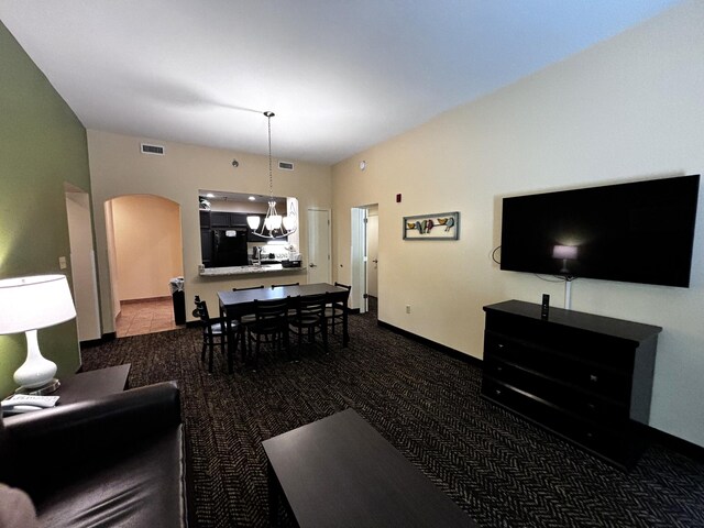 carpeted living room featuring a notable chandelier