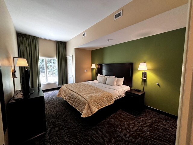 bedroom featuring dark carpet