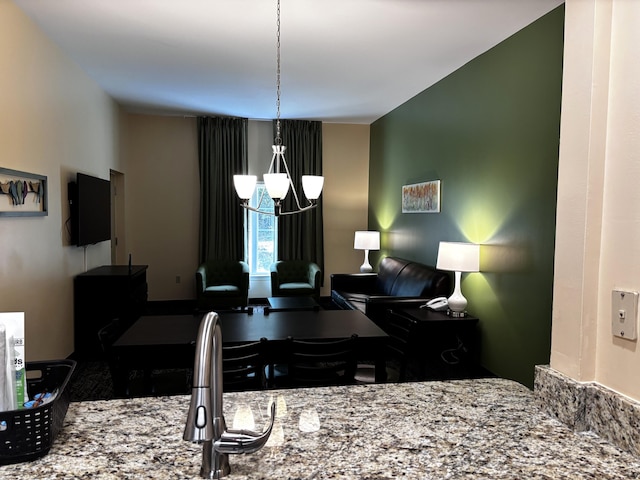 kitchen with light stone counters and a chandelier