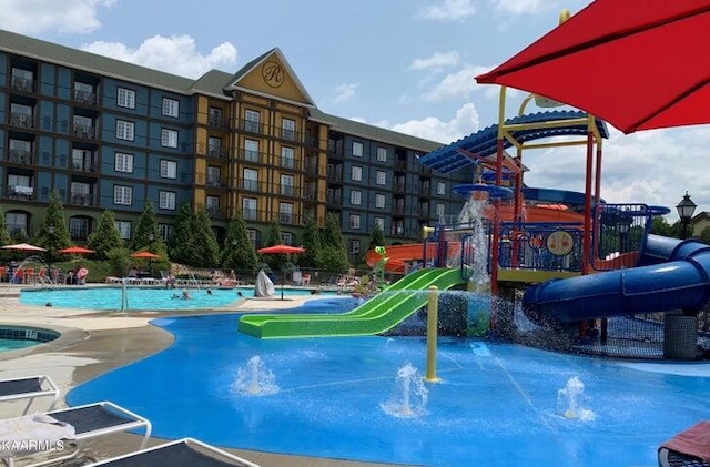 view of swimming pool with pool water feature and a water slide