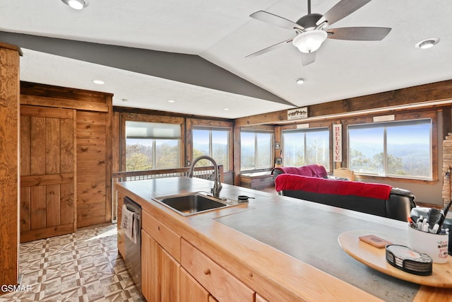 kitchen featuring light floors, vaulted ceiling, a sink, ceiling fan, and dishwasher