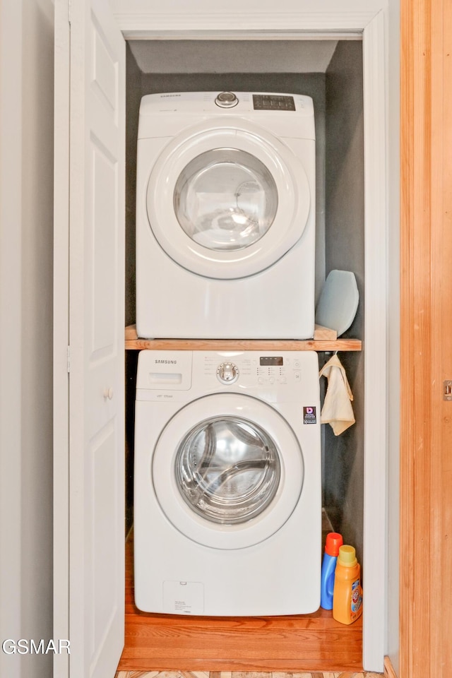 clothes washing area with laundry area and stacked washing maching and dryer