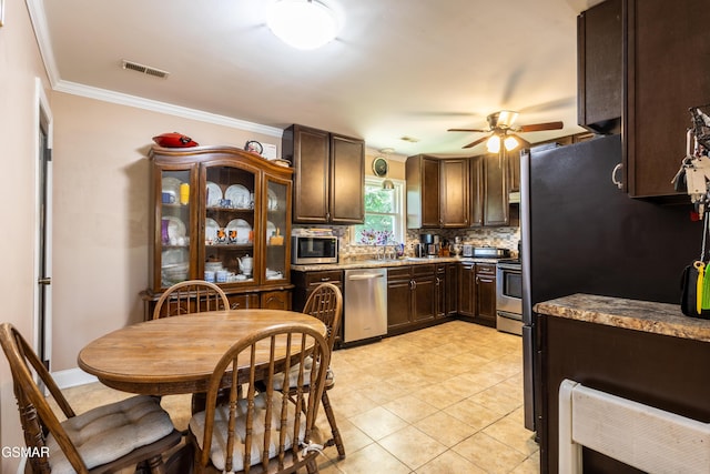 6119 Ridgeview Rd, Knoxville, TN 37918 - kitchen with appliances with stainless steel finishes, ceiling fan, dark brown cabinets, decorative backsplash, and crown molding