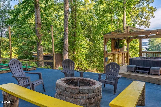 view of patio featuring an outdoor fire pit, a wooden deck, and a hot tub