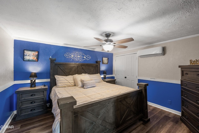 bedroom with ceiling fan, dark hardwood / wood-style flooring, a textured ceiling, an AC wall unit, and a closet