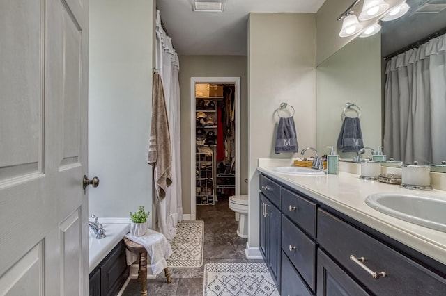 bathroom with a tub, vanity, and toilet