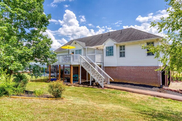 rear view of house with a yard and a wooden deck