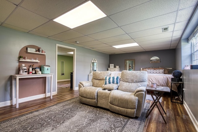 interior space with a paneled ceiling and dark wood-type flooring