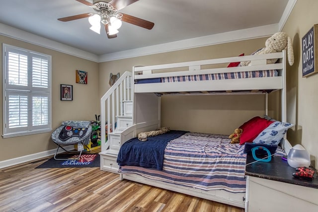 bedroom featuring ceiling fan, hardwood / wood-style flooring, and crown molding