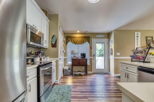 kitchen with appliances with stainless steel finishes, dark hardwood / wood-style flooring, white cabinetry, and decorative backsplash