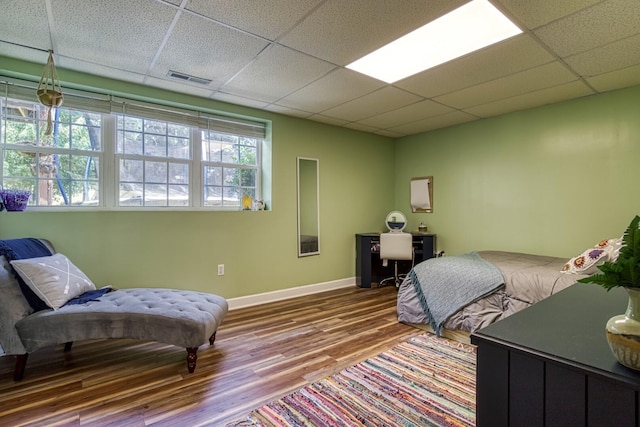 bedroom with a paneled ceiling and wood-type flooring