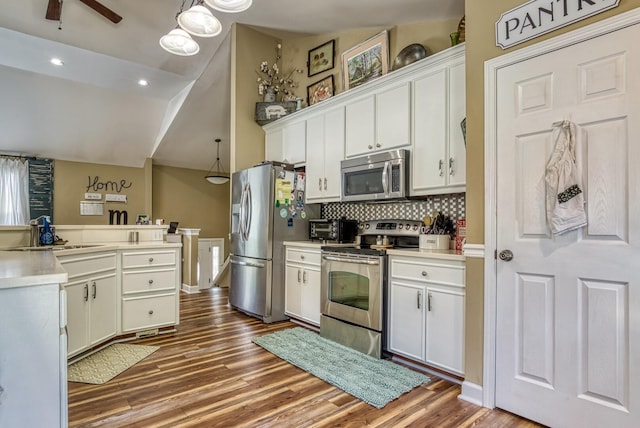 kitchen with stainless steel appliances, white cabinetry, hanging light fixtures, and sink