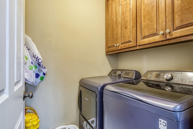 washroom with cabinets and washer and clothes dryer