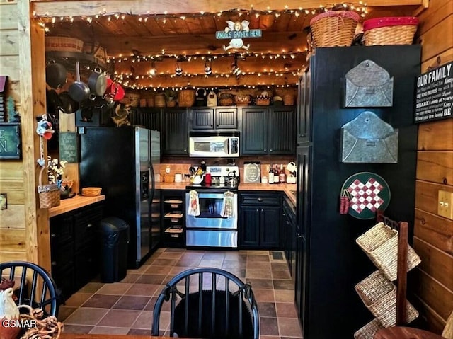 kitchen featuring stainless steel appliances, dark tile patterned floors, and light countertops