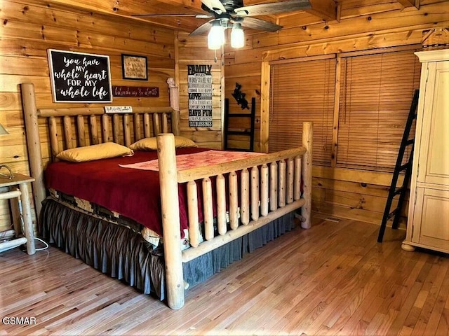 bedroom with wooden walls and wood finished floors