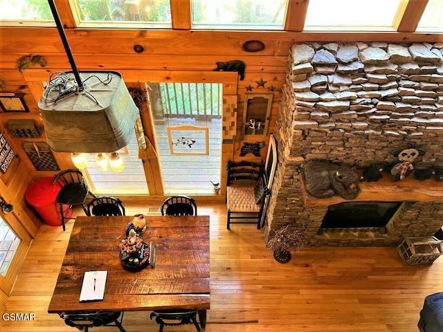 dining room with wooden walls, hardwood / wood-style floors, and a fireplace