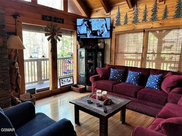 living area with beamed ceiling, wood ceiling, hardwood / wood-style floors, and wood walls