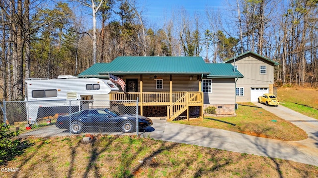 view of front facade with a ceiling fan, fence, driveway, a porch, and metal roof