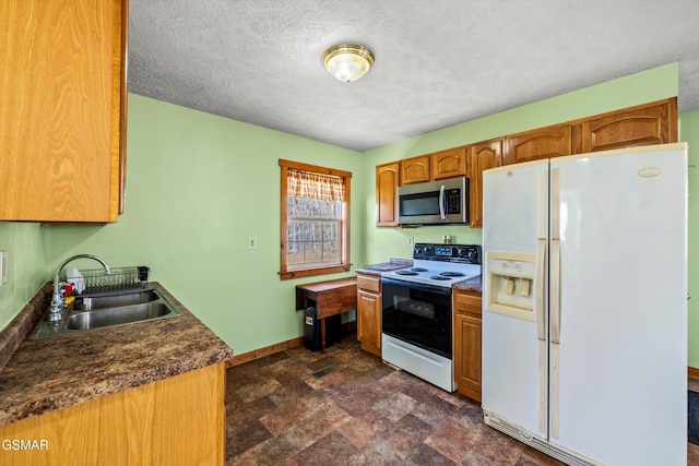 kitchen featuring a sink, stainless steel microwave, white refrigerator with ice dispenser, electric range oven, and baseboards