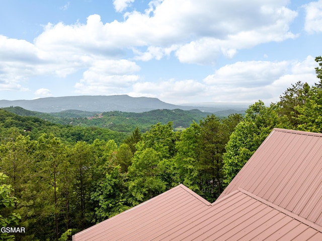 view of mountain backdrop featuring a forest