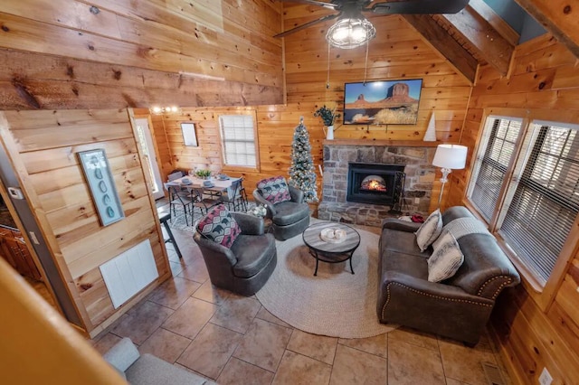 tiled living room with wooden walls, a healthy amount of sunlight, and vaulted ceiling with beams