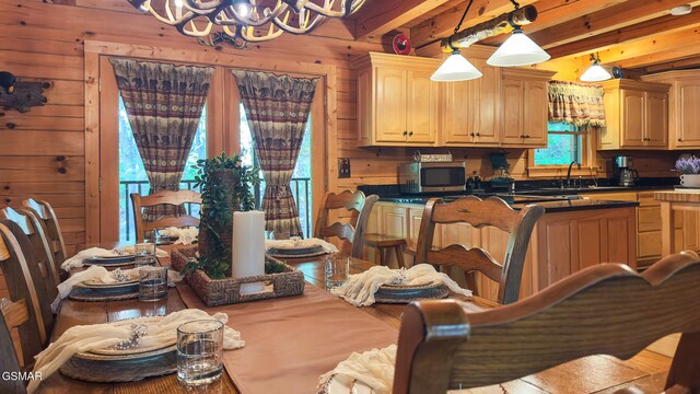 915 Statham Way, Gatlinburg, TN 37738 - kitchen with a chandelier, dark countertops, a sink, wood walls, and stainless steel microwave