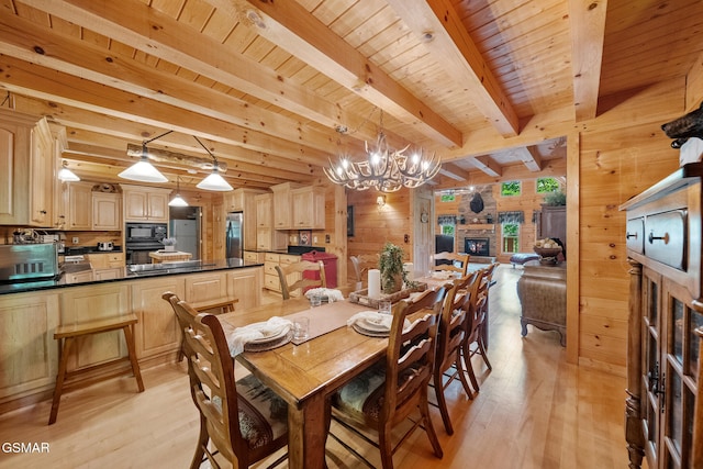 915 Statham Way, Gatlinburg, TN 37738 - dining space with a fireplace, light wood-style floors, wooden walls, a chandelier, and beam ceiling