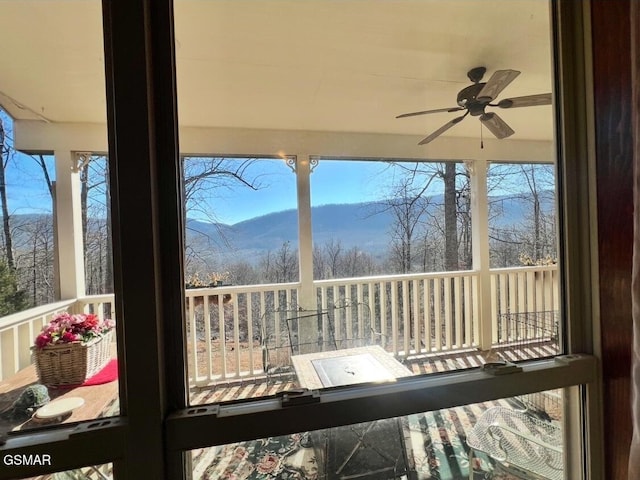 sunroom / solarium featuring ceiling fan and a mountain view