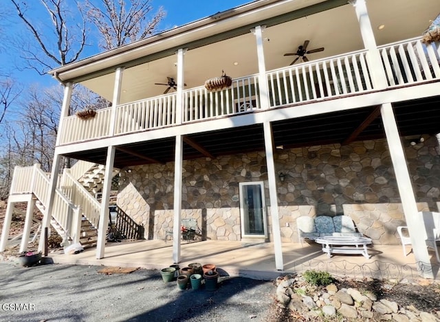 rear view of property with ceiling fan and a patio area