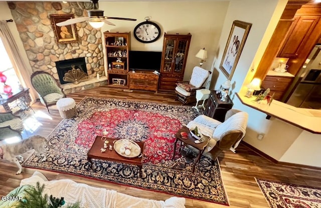 living room with ceiling fan, a fireplace, and hardwood / wood-style floors