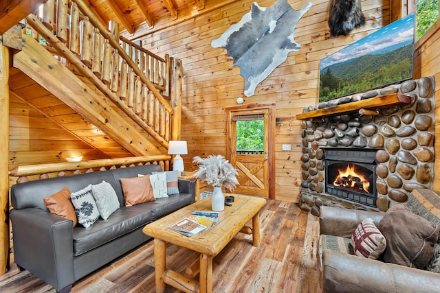 living room featuring lofted ceiling with beams, wood walls, a fireplace, wood ceiling, and hardwood / wood-style flooring