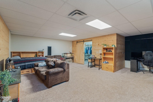1668 Deerwood Rd, Newport, TN 37821 - carpeted living area with a paneled ceiling, an office area, a barn door, wood walls, and concrete block wall
