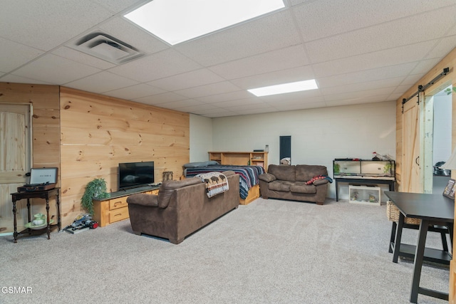 1668 Deerwood Rd, Newport, TN 37821 - living area with a barn door, carpet floors, wooden walls, a drop ceiling, and concrete block wall