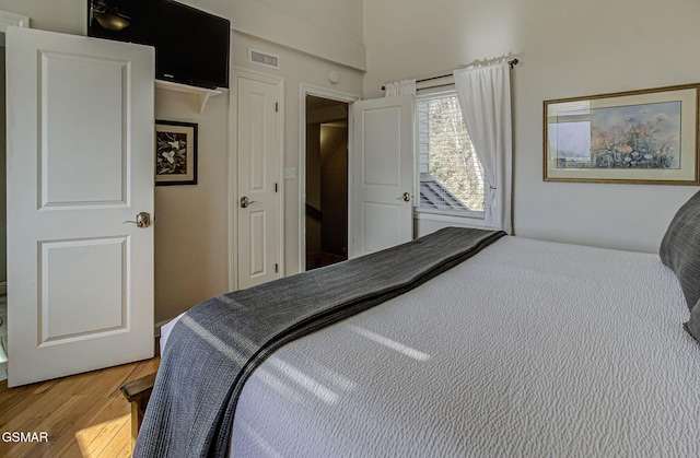 bedroom featuring wood finished floors and visible vents