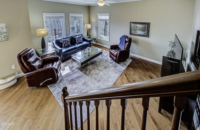 living room featuring baseboards, a ceiling fan, and wood finished floors